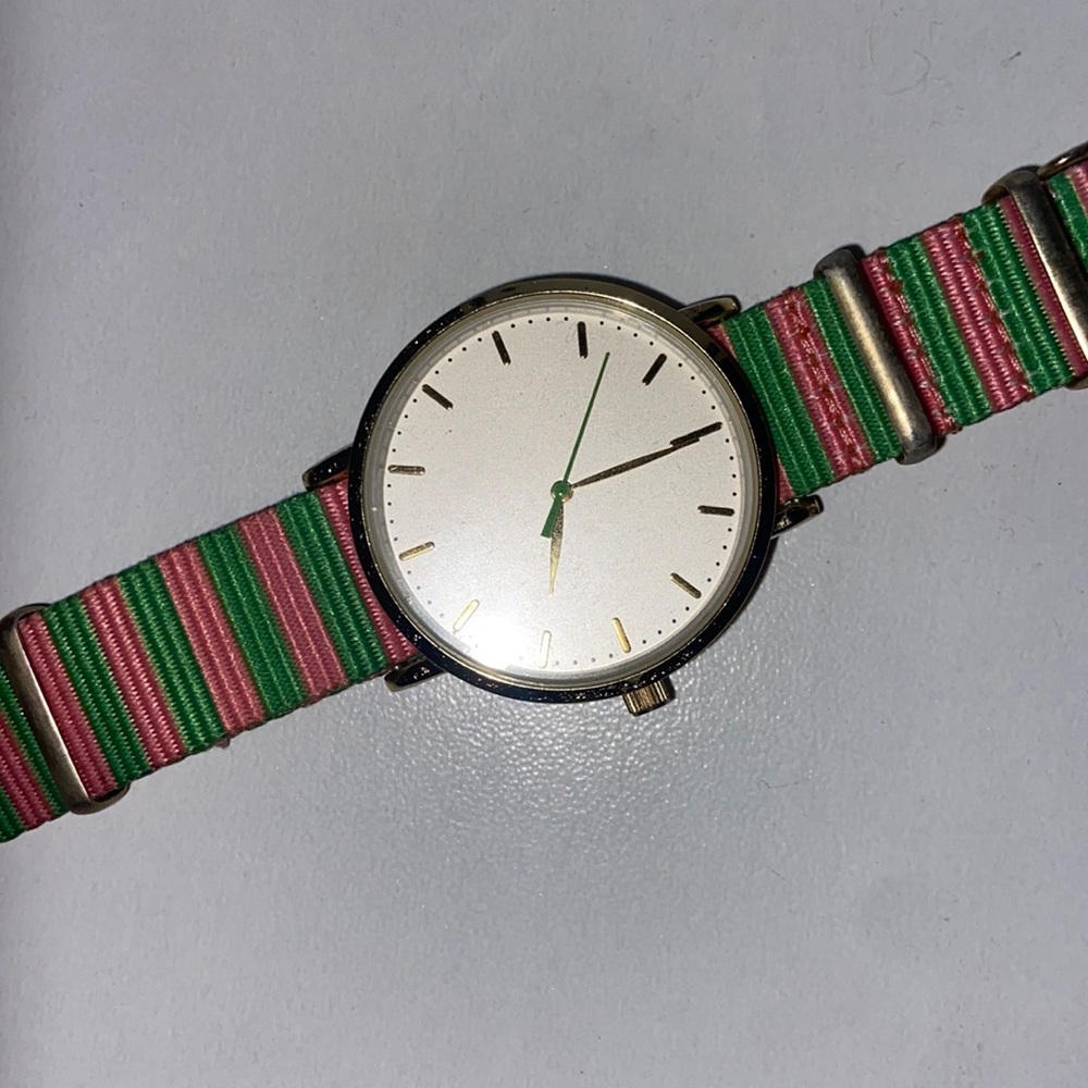 pink and green watch with gold and white watch face